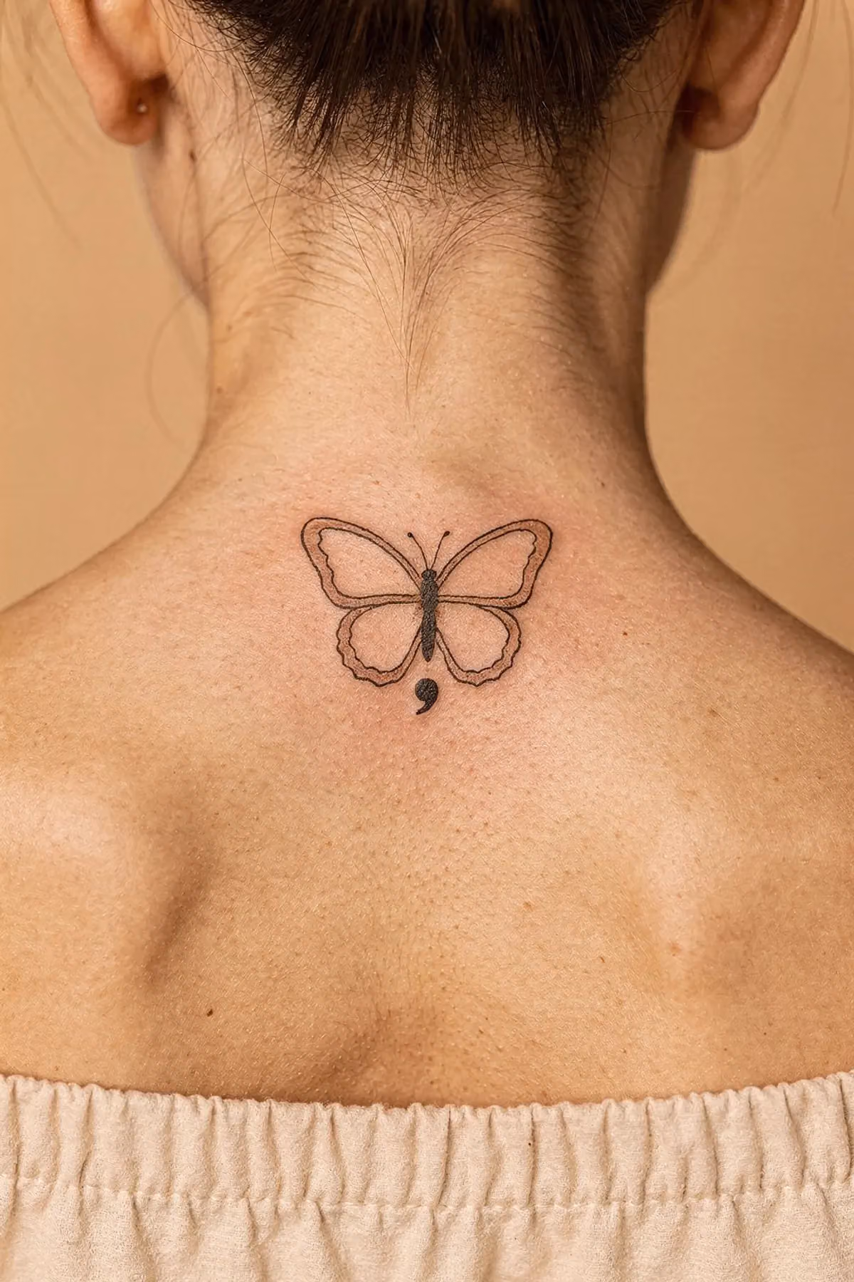Nackenansatz mit einem winzigen Schmetterling-Tattoo: Der Körper ein Semikolon, die Flügel nur zarte Umrisse