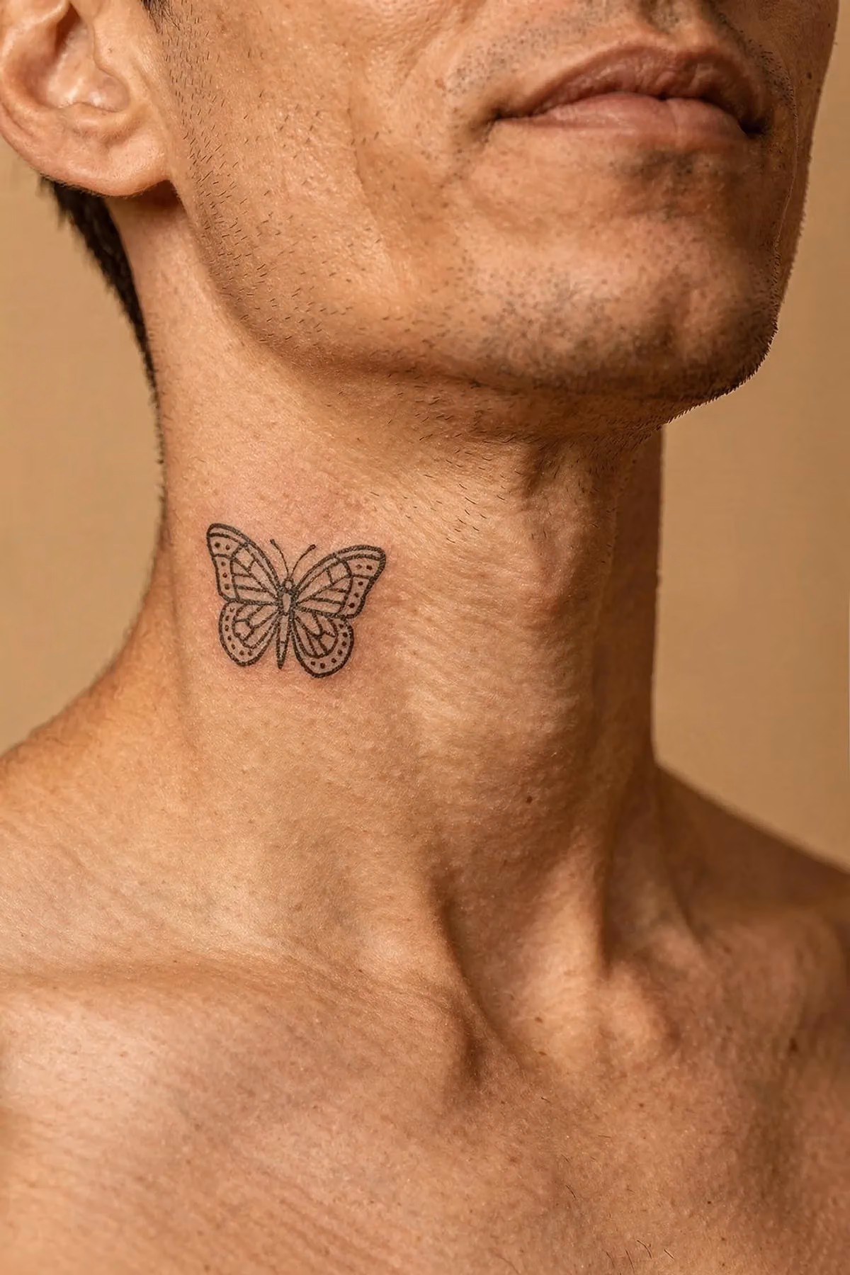 Geometrischer Schmetterling aus feinen Linien, Bögen und Punkten mittig unter dem Kinn.