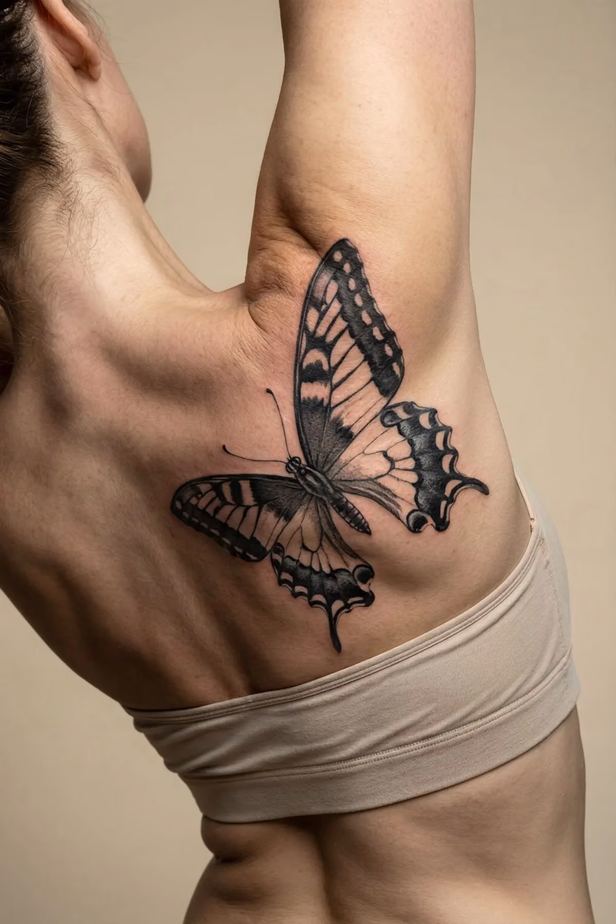 Schwarzer Schmetterling mit weißen Highlights erstreckt sich diagonal über den durchgebogenen Rücken einer Frau