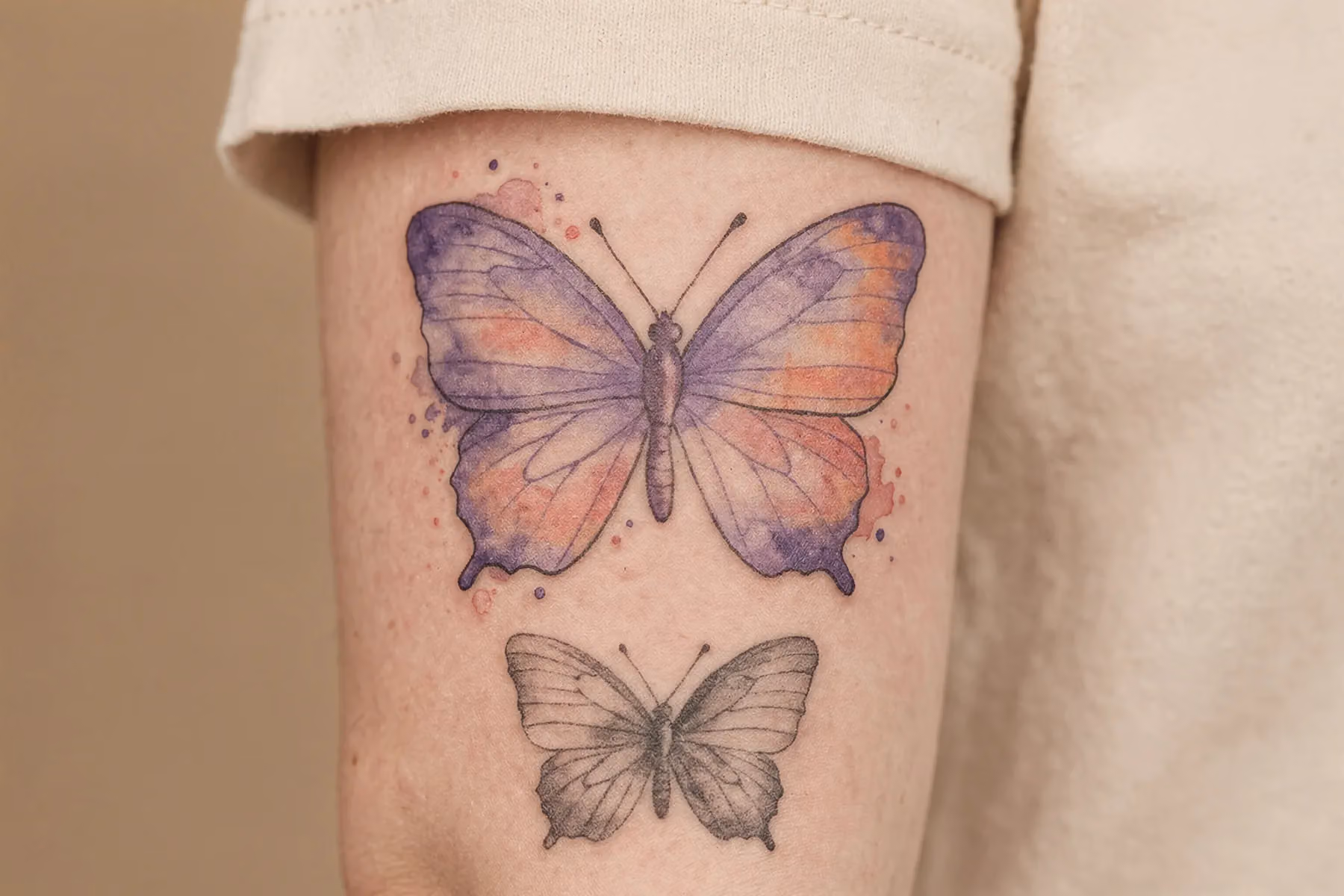 Nahaufnahmen bunter Schmetterling‑Tattoos auf warm‑beiger Haut mit Graustufen‑Mockups