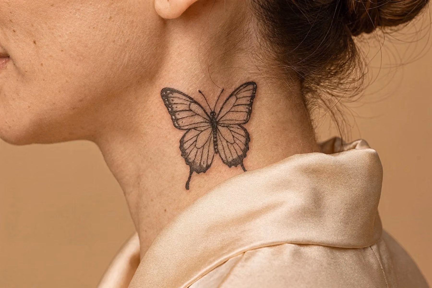 Schmetterling-Tattoo am Hals, seitlich platziert, mit ausgebreiteten Flügeln in Fineline-Technik